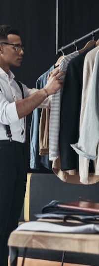 a man looking at clothes on a rack