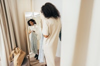 a woman is standing in front of a mirror looking at herself in the mirror